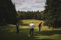 three people watching golf